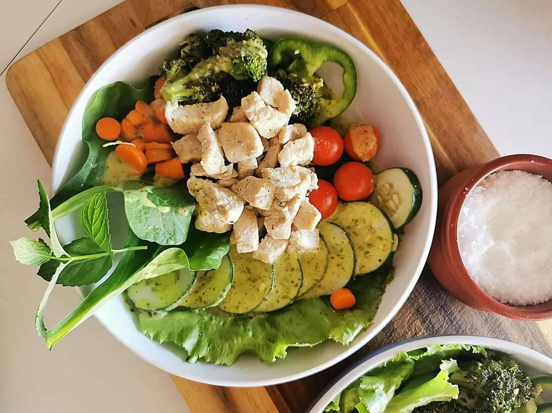 Bowl of dairy-free calcium-rich foods including tofu, broccoli, leafy greens, cucumber, carrots, and cherry tomatoes.